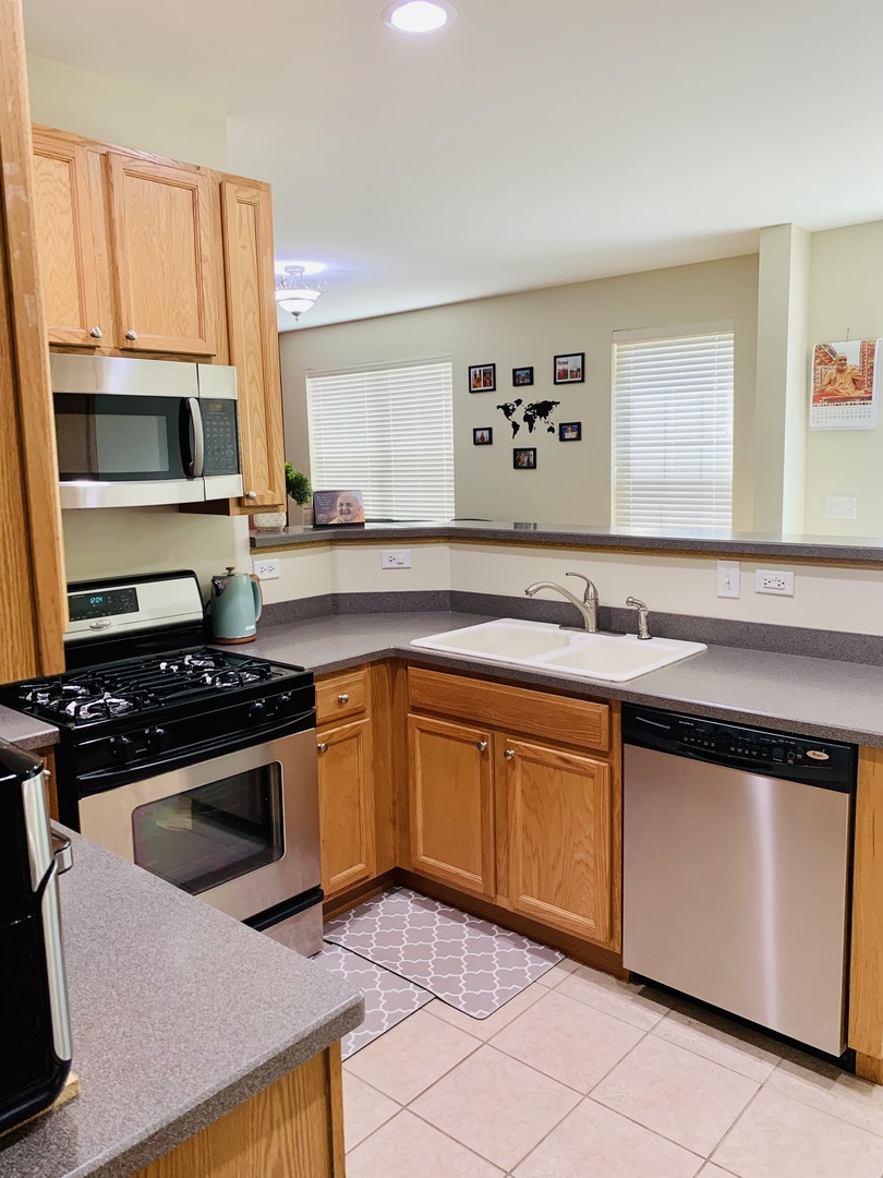 146 Goldenhill Street Carol Stream, IL 60188 - Photo 5 of 18 a kitchen with stainless steel appliances granite countertop a stove a sink and a microwave