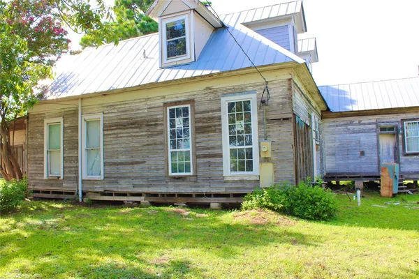 a view of a house with a yard and sitting area