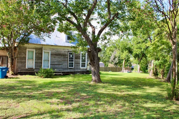 a backyard of a house with yard and tree