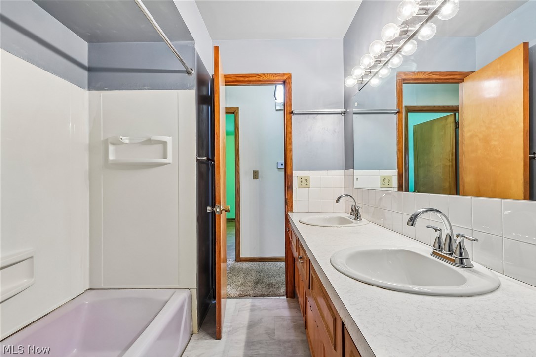 2758 Shellhart Road Norton, OH 44203 - Photo 19 of 41 First floor full bath with double sink / vanity, shower / tub combo, special lighting, commode and tile flooring
