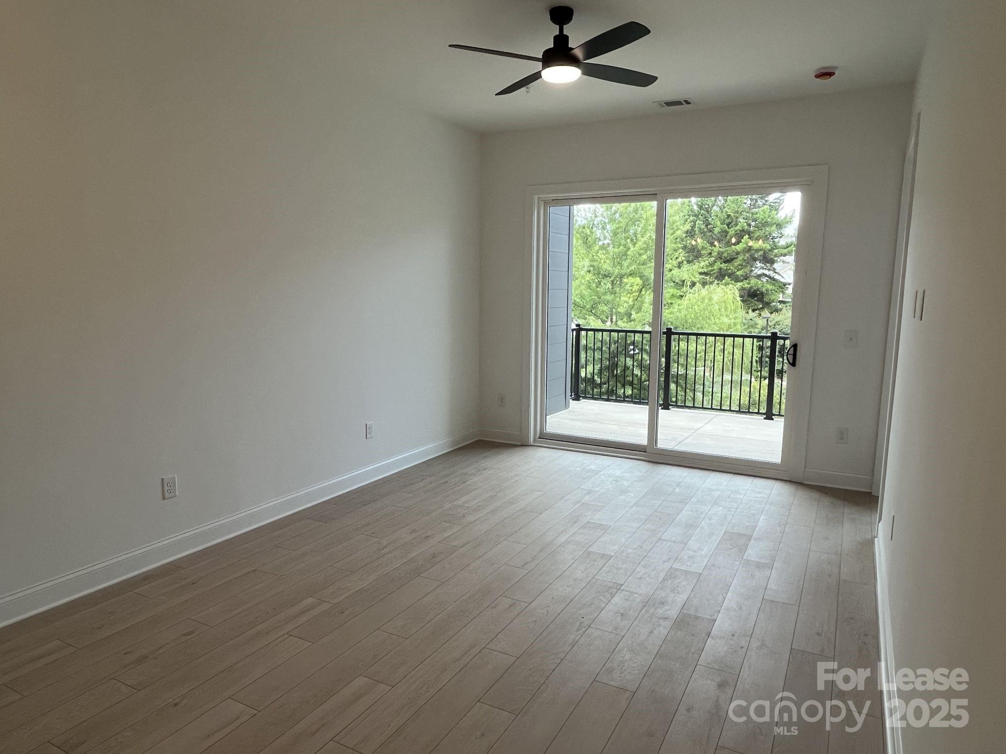 19546 Greentree Way, Unit 203 Cornelius, NC 28031 - Photo 16 of 32 an empty room with wooden floor fan and windows