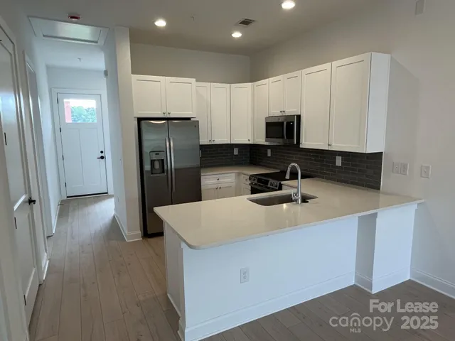 a kitchen with stainless steel appliances granite countertop a stove a sink and a microwave