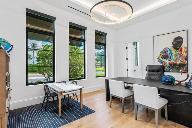 a view of white house with a big yard and palm trees