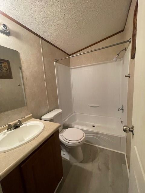 3125 Bois D Arc Road Combine, TX 75159 - Photo 11 of 15 Full bathroom featuring washtub / shower combination, a textured ceiling, lofted ceiling, toilet, and vanity