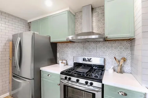 a kitchen with stainless steel appliances granite countertop a refrigerator and a stove