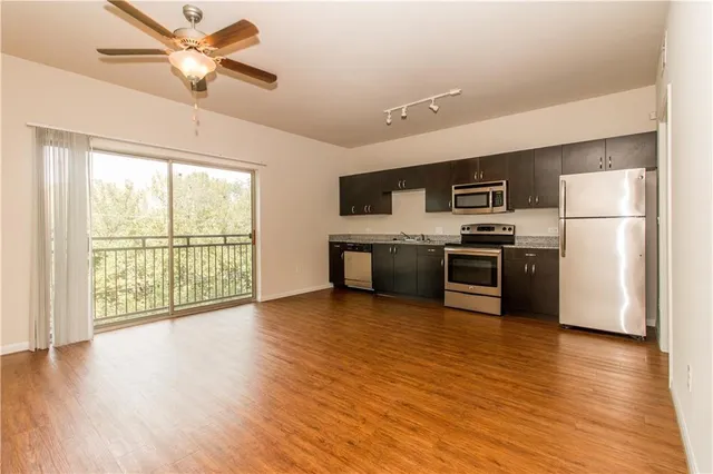 a view of kitchen with granite countertop stainless steel appliances and wooden floor
