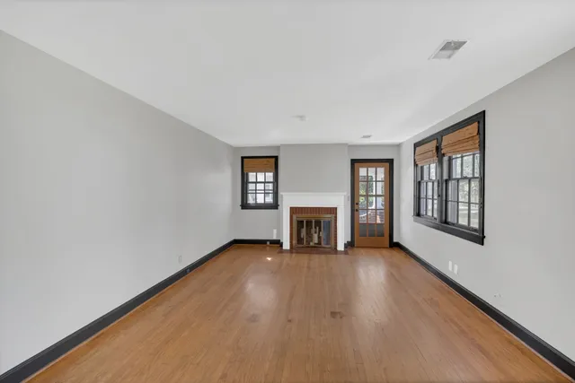 a view of an empty room with a fireplace and a window
