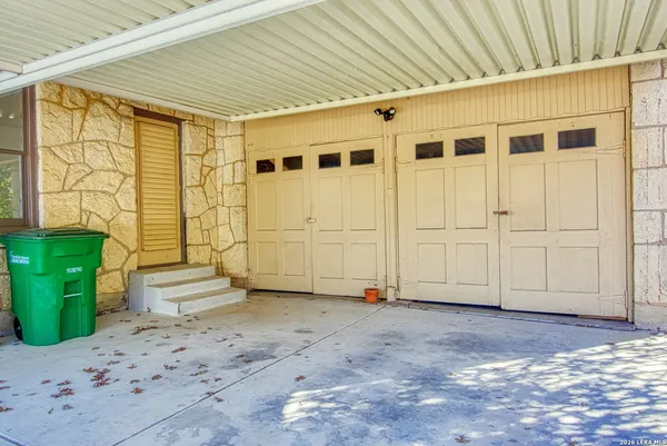 a view of an empty room with wooden floor and a fireplace