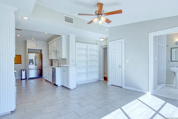 a kitchen with stainless steel appliances white cabinets and a stove top oven