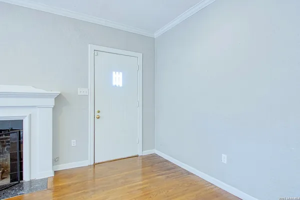 a view of an empty room with wooden floor and closet