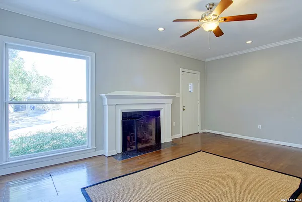 wooden floor fireplace and windows in an empty room