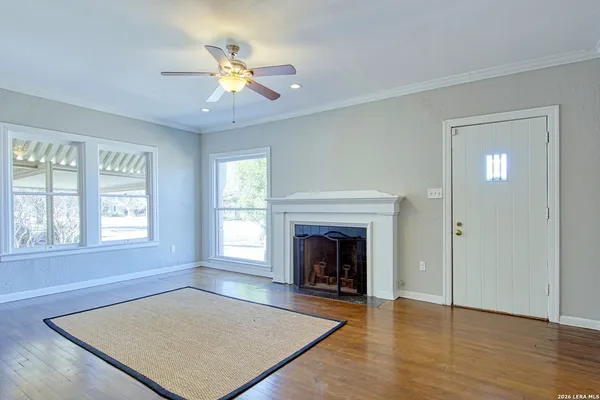 an empty room with windows and fireplace