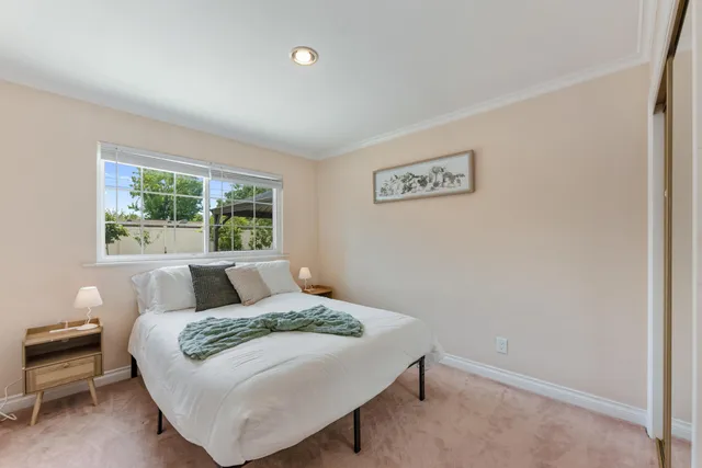 a bed sitting in a bedroom next to a window