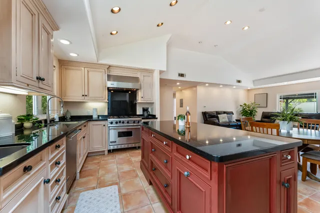 a large kitchen with stainless steel appliances granite countertop a stove a sink dishwasher and a refrigerator