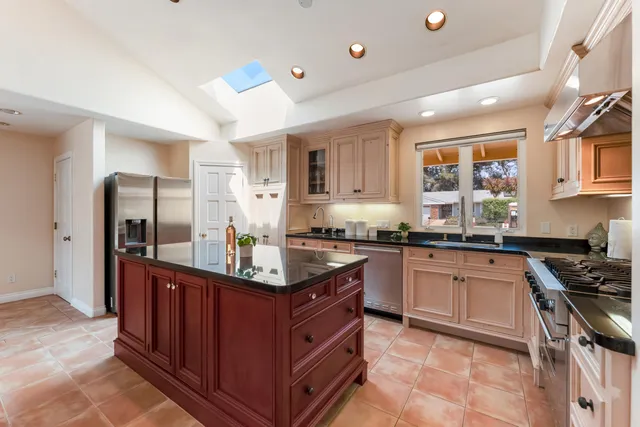 a kitchen with stainless steel appliances granite countertop a stove a sink dishwasher and a refrigerator