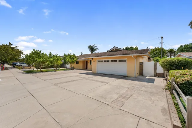a view of a house with backyard and trees