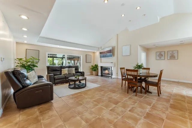 a living room with furniture and a dining table with garden view