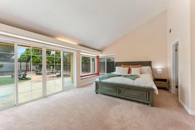 a spacious bedroom with a bed and a large window