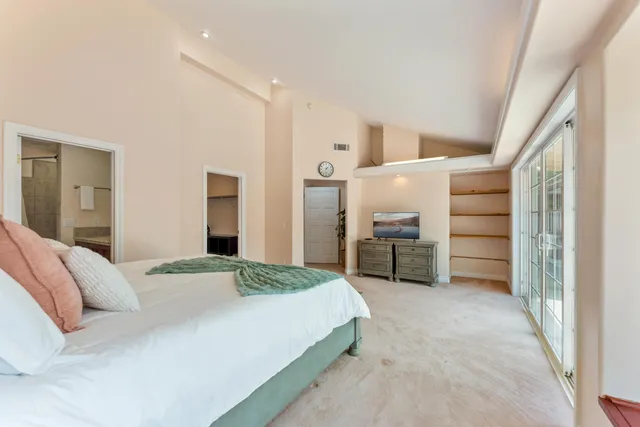 a spacious bedroom with a bed and a cabinets