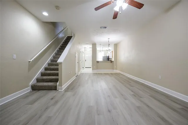 wooden floor in an empty room with a chandelier