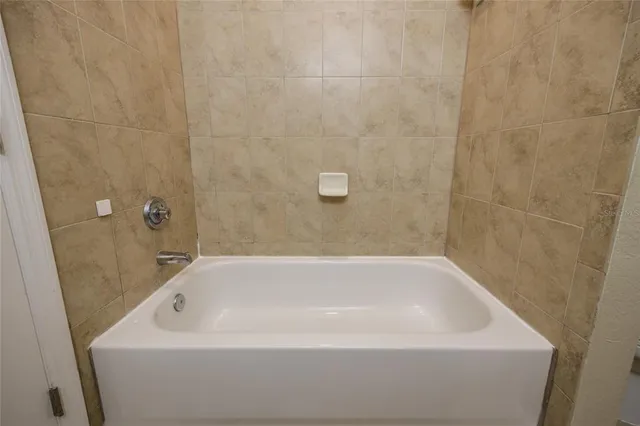 a bathroom with a white bath tub and a shower