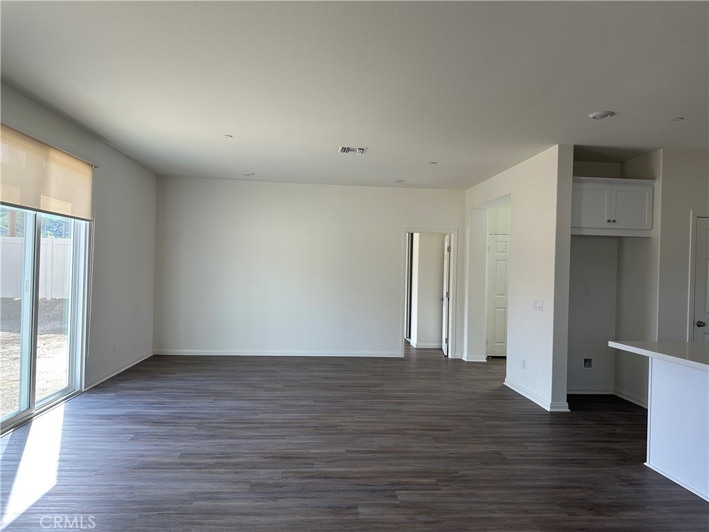 7560 Citrusmoon Court Riverside, CA 92507 - Photo 5 of 18 a view of an empty room with wooden floor and a window