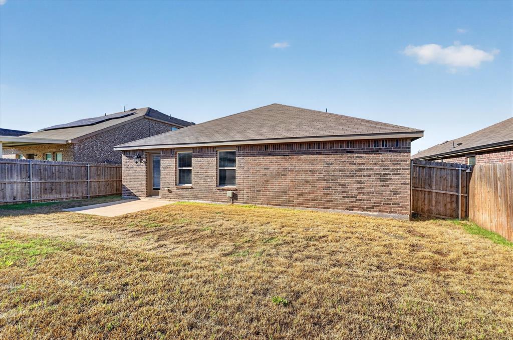 2428 Rosharon Drive Forney, TX 75126 - Photo 28 of 40 Brick exterior with multiple windows, leading to a concrete patio