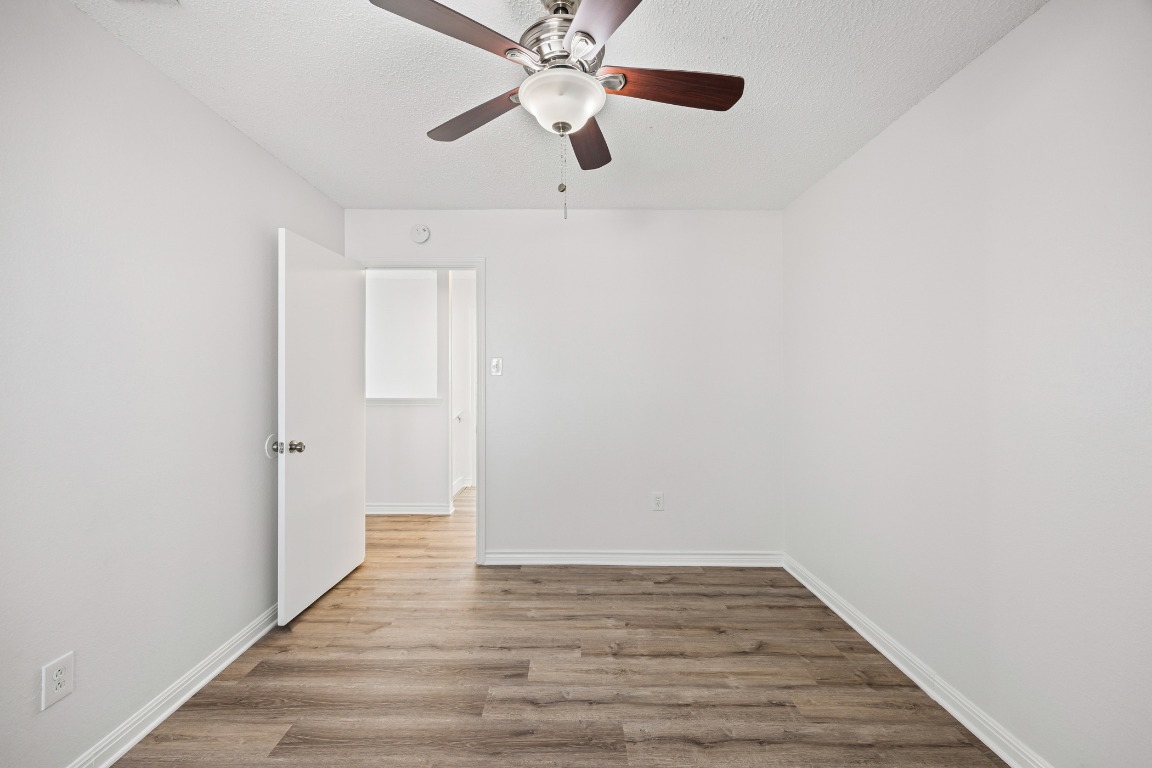 2630 Alcott Lane, Unit A Austin, TX 78748 - Photo 16 of 32 Unfurnished room featuring light wood-style floors, a ceiling fan, and a textured ceiling