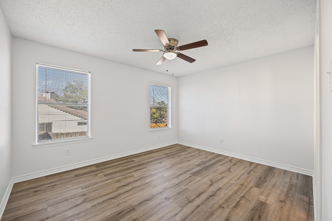2630 Alcott Lane, Unit A Austin, TX 78748 - Photo 17 of 32 Empty room with a textured ceiling, wood finished floors, and a ceiling fan