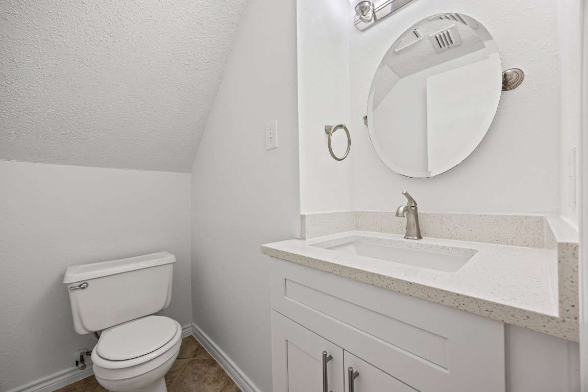 2630 Alcott Lane, Unit A Austin, TX 78748 - Photo 22 of 32 Bathroom with a textured ceiling, vanity, vaulted ceiling, and light tile patterned flooring