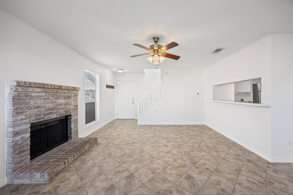 2630 Alcott Lane, Unit A Austin, TX 78748 - Photo 9 of 32 Unfurnished living room featuring a fireplace and a ceiling fan