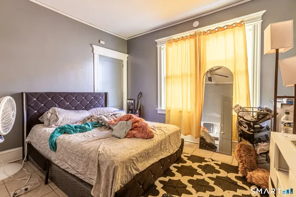 a bedroom with a bed and wooden floor