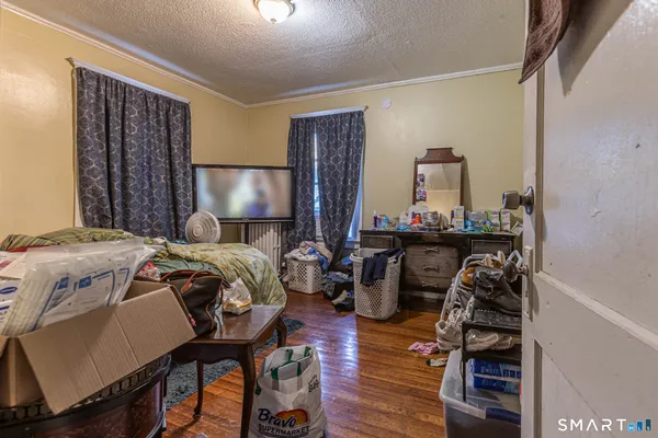 a bedroom with a bed and wooden floor
