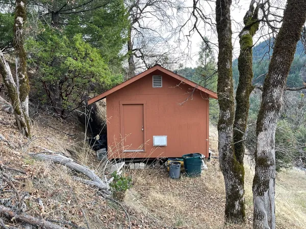 a wooden house with a tree in the background