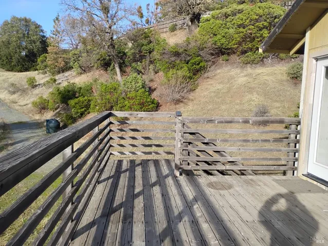 a view of balcony with wooden floor and fence