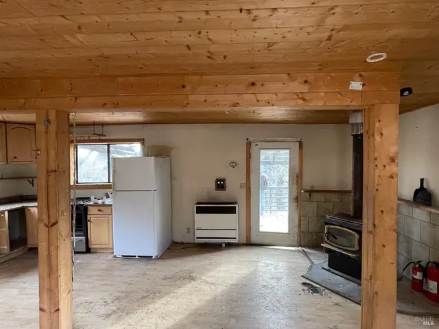 a view of a kitchen with furniture and a refrigerator