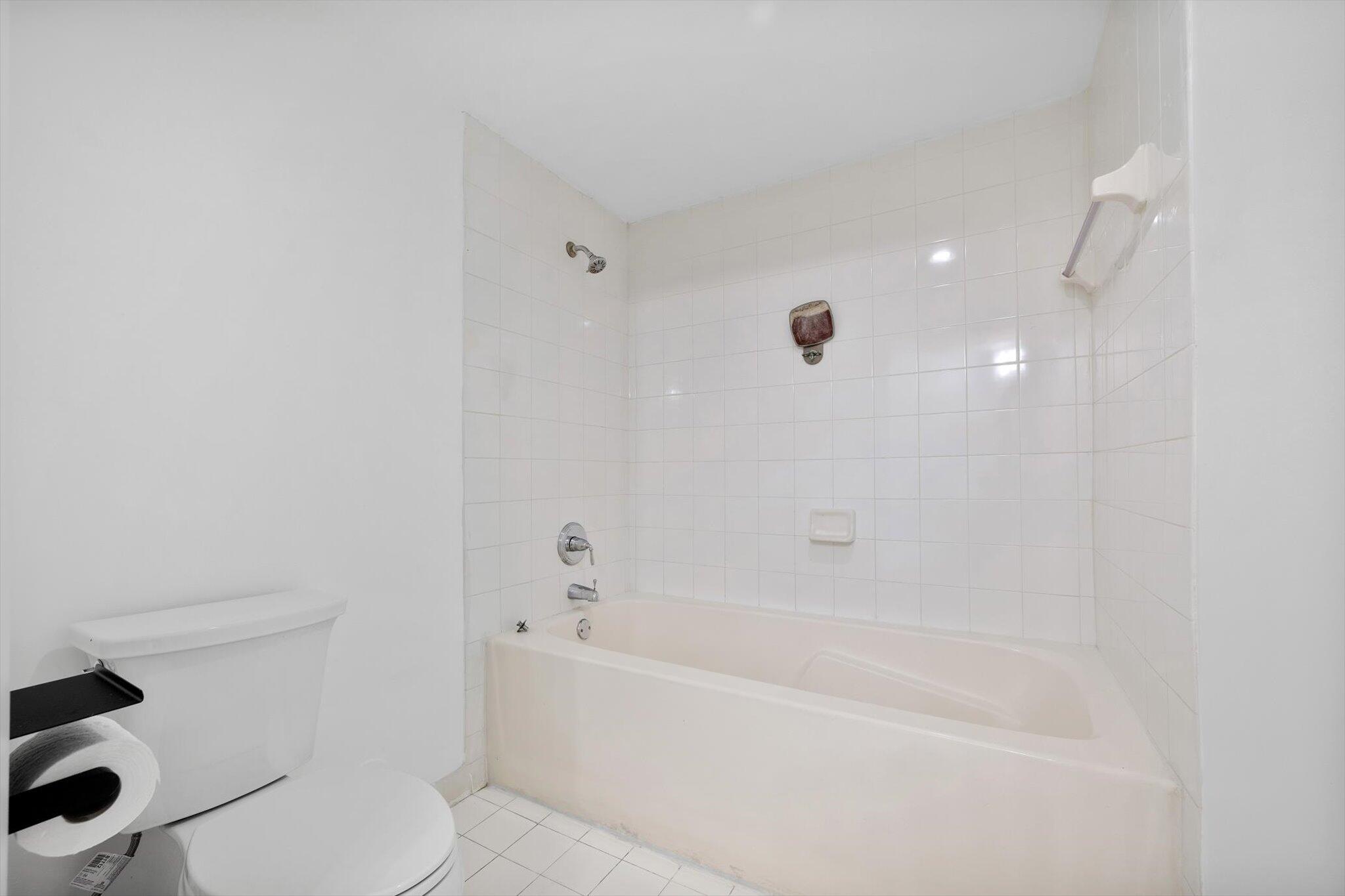 7270 Southwest 88th Street, Unit B203 Miami, FL 33156 - Photo 14 of 27 a white bath tub sitting next to a toilet