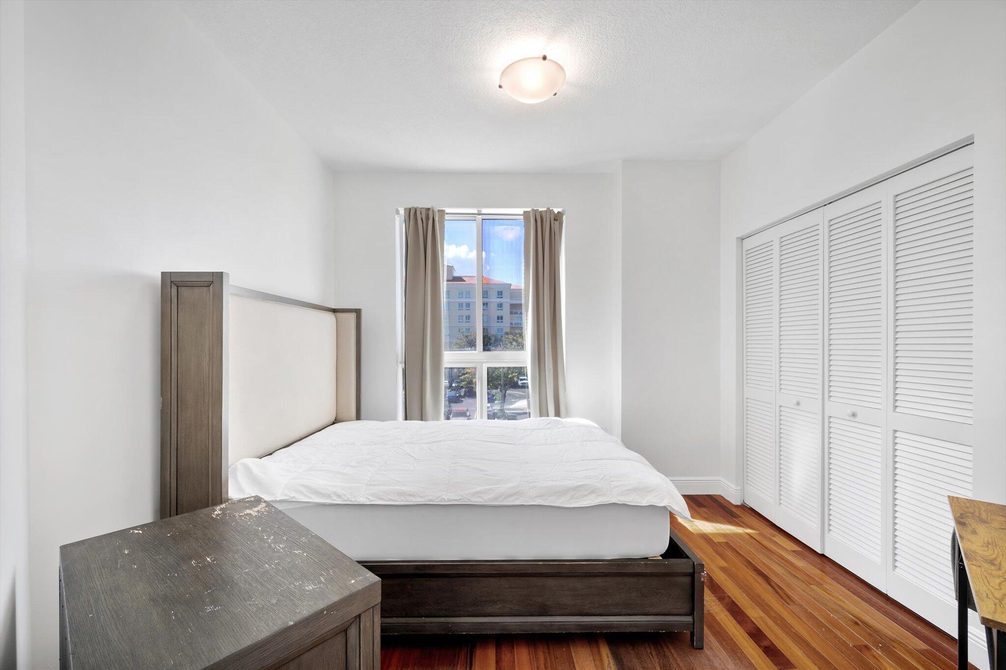 7270 Southwest 88th Street, Unit B203 Miami, FL 33156 - Photo 15 of 27 a bed sitting in a bedroom next to a window