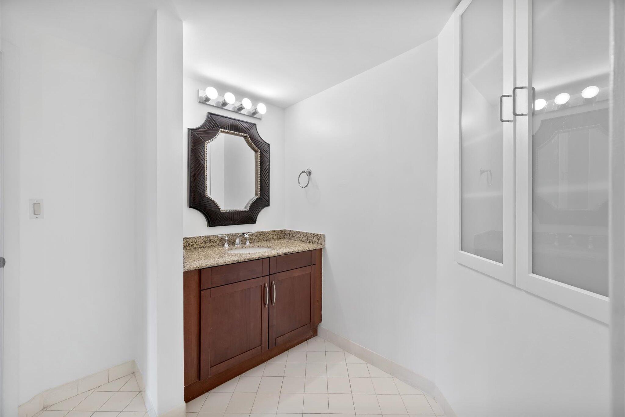 7270 Southwest 88th Street, Unit B203 Miami, FL 33156 - Photo 18 of 27 a view of a bathroom with a sink and mirror