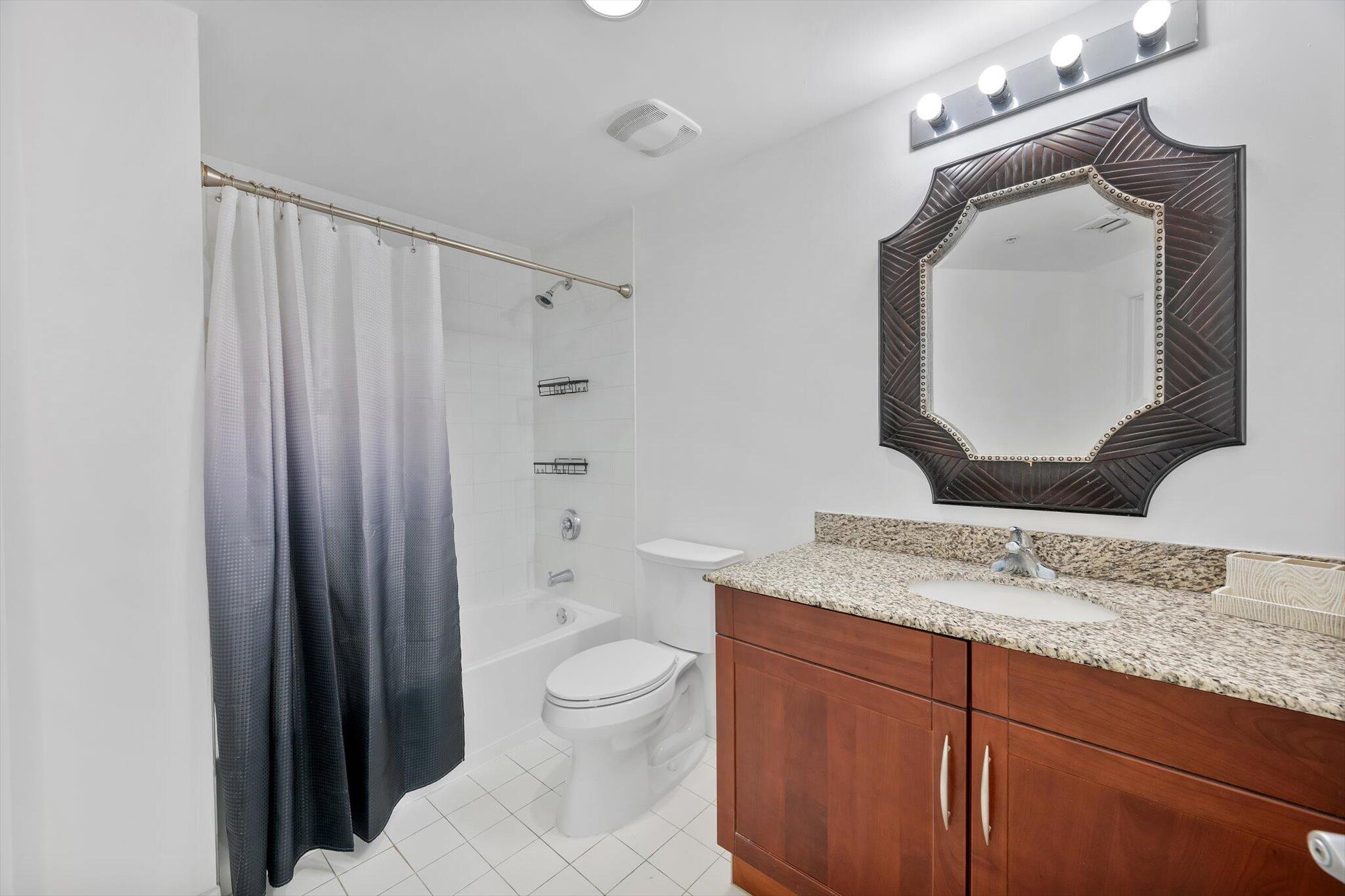 7270 Southwest 88th Street, Unit B203 Miami, FL 33156 - Photo 19 of 27 a bathroom with a granite countertop sink mirror vanity and toilet