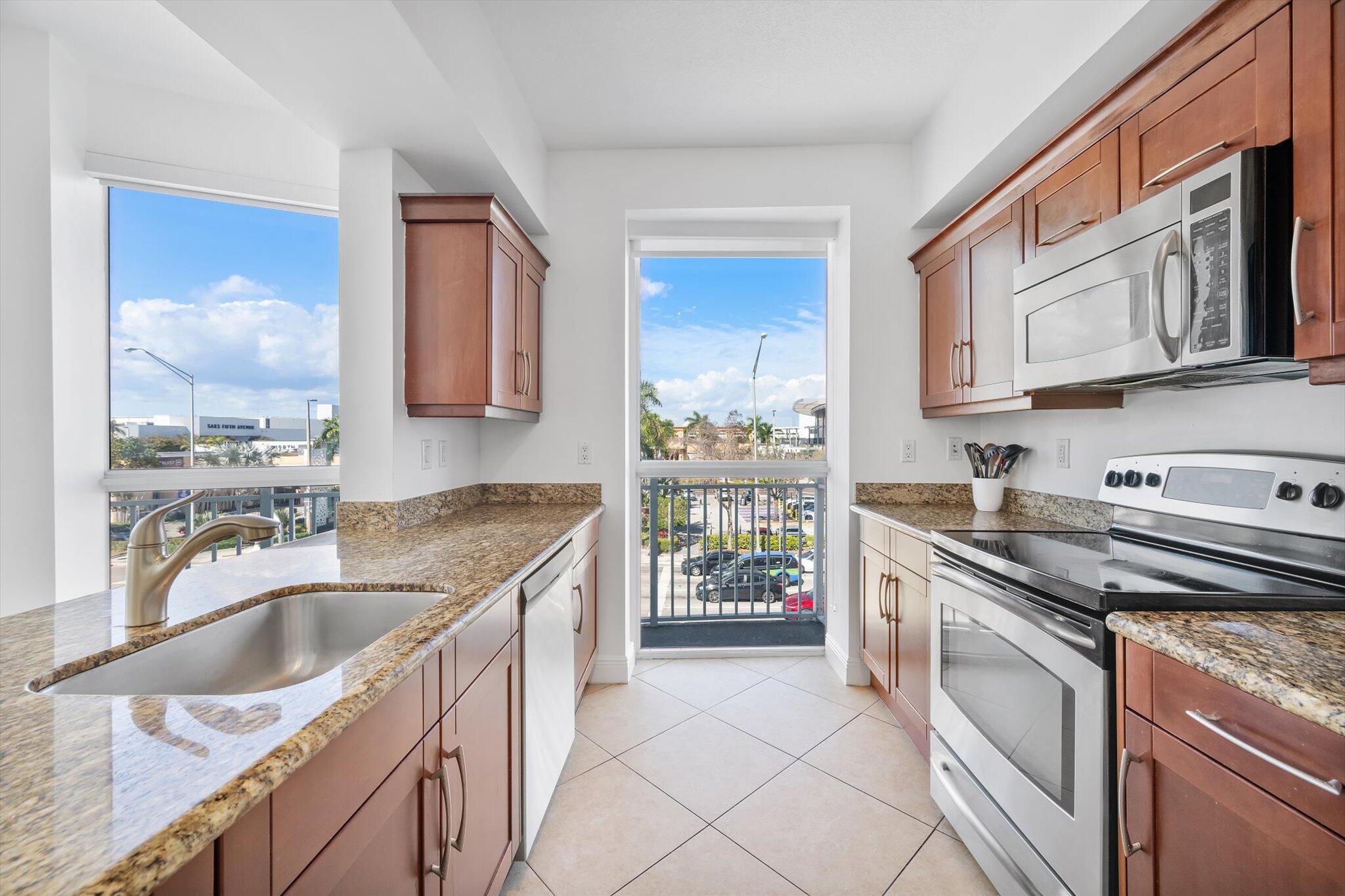 7270 Southwest 88th Street, Unit B203 Miami, FL 33156 - Photo 5 of 27 a kitchen with stainless steel appliances granite countertop a sink stove and refrigerator
