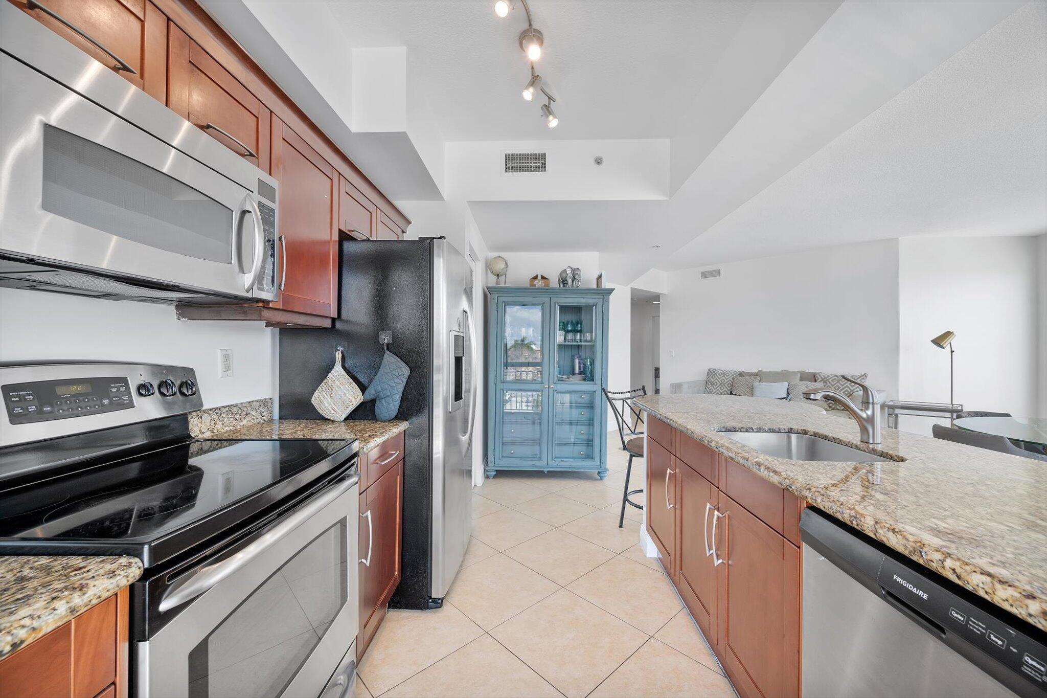 7270 Southwest 88th Street, Unit B203 Miami, FL 33156 - Photo 6 of 27 a kitchen with stainless steel appliances granite countertop a sink and stove
