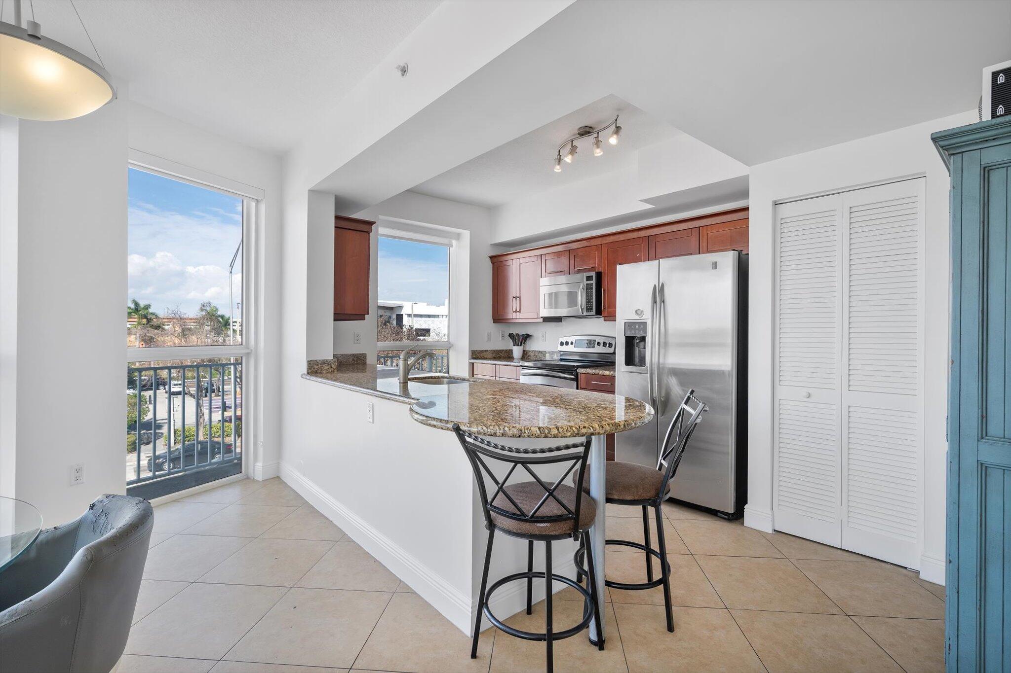 7270 Southwest 88th Street, Unit B203 Miami, FL 33156 - Photo 8 of 27 a dining room with furniture and a kitchen view