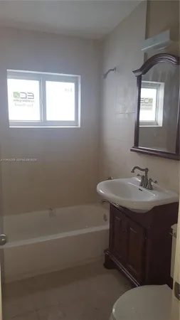 a bathroom with a sink toilet vanity and bathtub