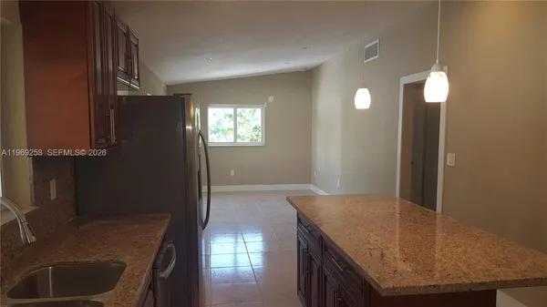 a kitchen with granite countertop a sink and a stove