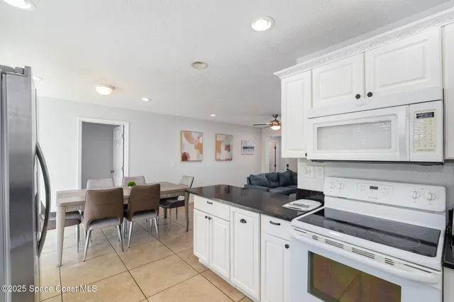 a kitchen with granite countertop a sink appliances cabinets and furniture