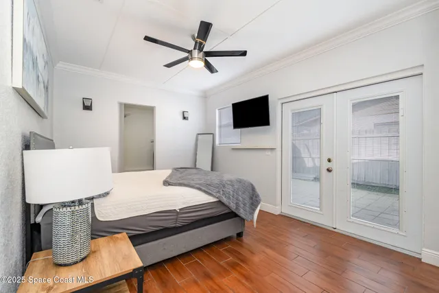 a bedroom with a bed a couch and a flat screen tv