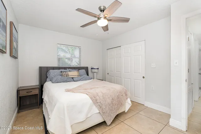 a bedroom with a bed and a ceiling fan