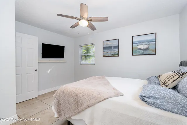 a bedroom with a large bed and a flat screen tv