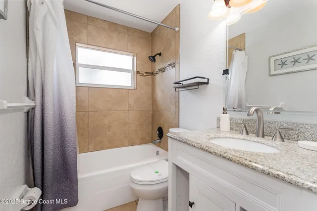 a bathroom with a granite countertop sink a toilet and shower
